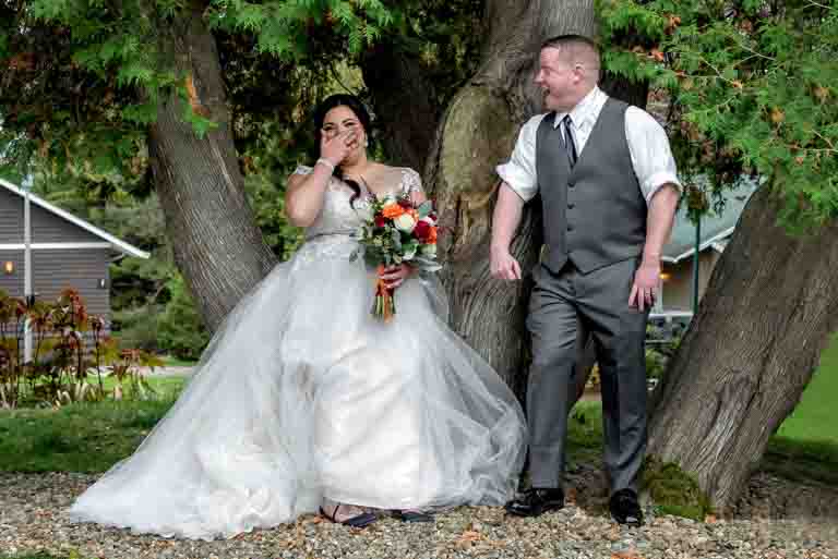 A bride and groom joke with each other during their wedding photos at Digby Pines Resort in Nova Scotia.