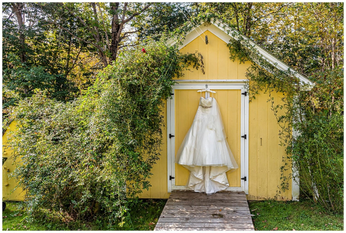 A stunning wedding dress hangs from a barn door in Lunenburg NS.